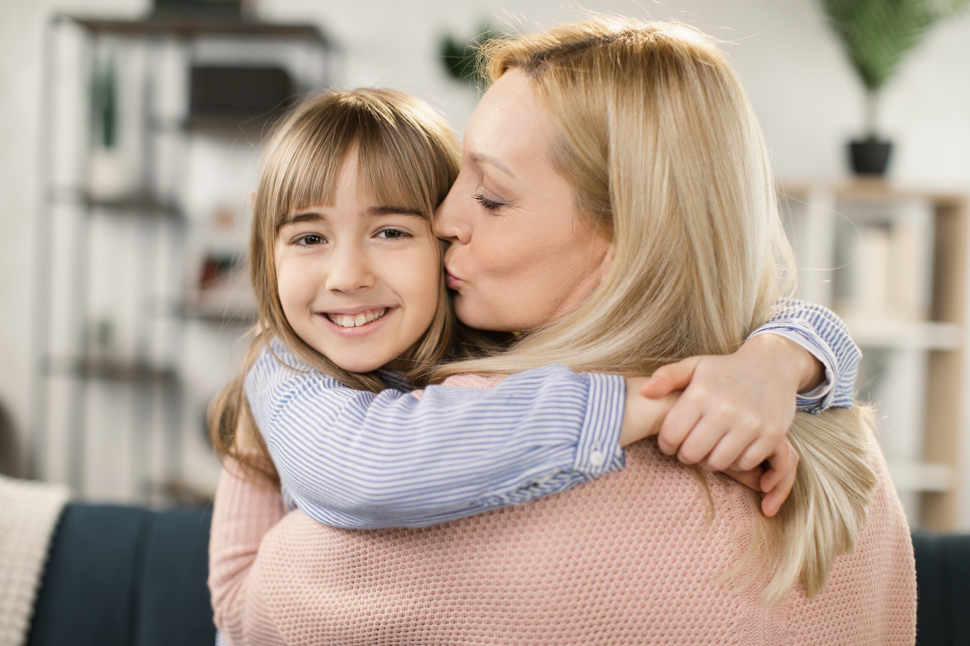 Happy loving single mom hugging cute little adopted kid daughter laughing bonding